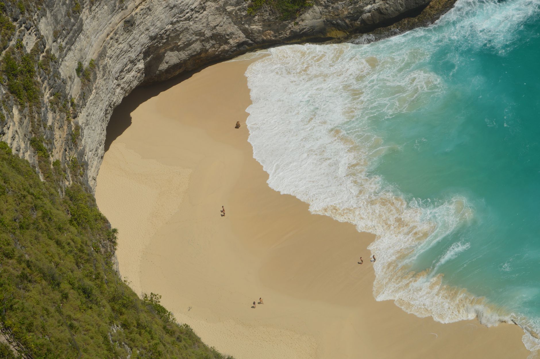 Pantai Kuta Bali dengan ombak biru dan pasir putih yang menawan.